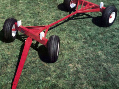 A red trailer on a grassy field.