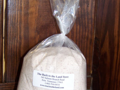 A bag of flour sitting on a wooden table.