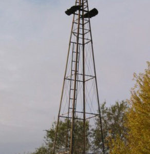 A windmill standing in the middle of a field.