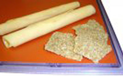 A tray with two sticks and a piece of cheese on it.