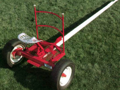 A red and white cart on a grassy field.