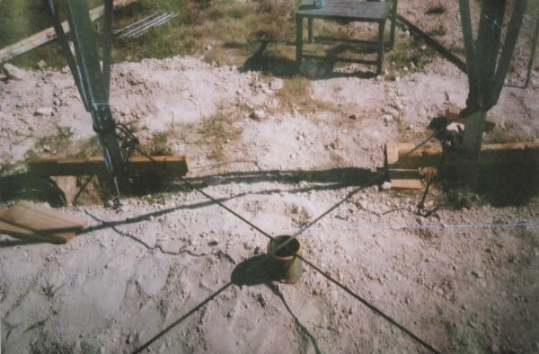 A picture of a wooden pole in a dirt field.